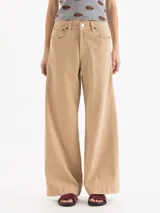 Jeans wide leg de denim de algodón color arena, de tiro medio-alto con perneras amplias y bolsillos clásicos.
