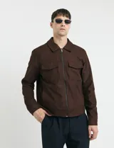 Campera Harrington de gamuza en color marrón, con cierre frontal, cuello clásico y bolsillos laterales con solapa.