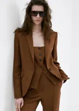 Pantalón marrón de lino, corte recto de tiro medio, con bolsillos laterales y traseros de ribete, trabillas y cierre oculto.