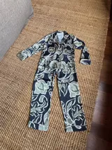 Pijama de seda estampado, compuesto por una camisa de manga larga con botones y un pantalón recto con elástico en la cintura.