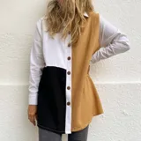 Camisa larga de lino con diseño color block en blanco, negro y ocre. Tiene cuello clásico, mangas largas con puños abotonados y cierre frontal con botones de madera.