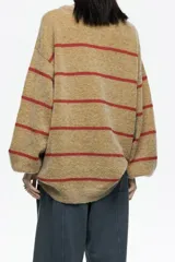 Sweater de punto largo con corte oversize, confeccionado en una mezcla de mohair y lana. Presenta un diseño a rayas horizontales en color mostaza y rojo, con escote barco redondeado y mangas largas holgadas.
