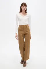 Pantalón de algodón color tostado, de tiro alto y corte flare con bolsillos laterales y vivos decorativos.