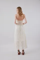 Vestido midi de tirantes finos en color blanco, con escote en V profundo y diseño con textura floral bordada y sutiles lentejuelas brillantes.