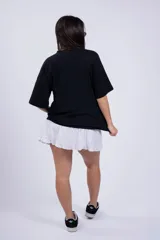 Minifalda negra de tussor con cintura elastizada y volado en el ruedo.