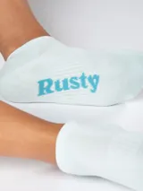Medias tobilleras color celeste con la palabra "Rusty" en azul.