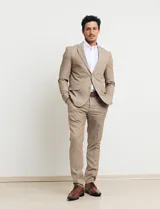 Ambo de dos piezas color tostado, compuesto por un saco entallado de dos botones y pantalón de vestir de corte recto.