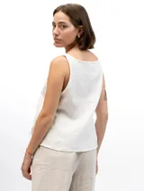Musculosa de lino con cuello redondo, diseño holgado y laterales abiertos unidos por tres tiras horizontales.