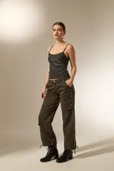 Pantalon cargo de algodón color gris oscuro, de tiro alto y corte recto. Presenta bolsillos laterales tipo cargo y una hilera de ojales metálicos decorativos a lo largo de la pierna derecha.