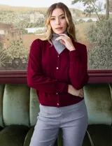 Cardigan rojo tejido en hilado fino, con escote en V y abertura central con botones metálicos.