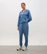 Campera deportiva de modal negro con capucha, cierre frontal por cremallera, cordones ajustables, bolsillos y mangas largas con puños elásticos.