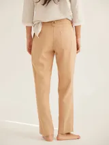 Pantalón de corte cigarette con cintura de tiro medio, cierre frontal con botón y bolsillos laterales. Presenta un diseño clásico de líneas limpias y dobladillo con costura visible.