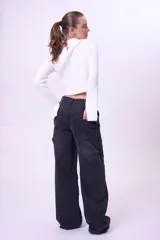 Blusa de punto acanalado color blanco, con cuello alto, corte cropped y mangas largas acampanadas.