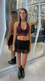 Top corto color bordó con escote halter y espalda descubierta, confeccionado en tela con lentejuelas.