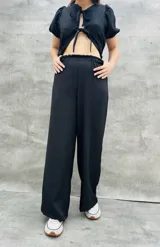 Pantalón palazzo negro de corte amplio con cintura elastizada.