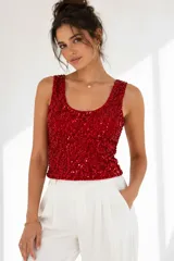 Musculosa de terciopelo roja cubierta íntegramente de paillettes, con escote redondo y tirantes anchos.