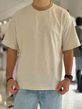 Remera oversize de manga corta con diseño a rayas finas, cuello redondo en color marrón tostado y calce relajado.