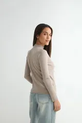 Polera de tejido de punto fino color bordó, con cuello alto y mangas largas.