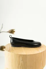 Zapato tipo ballerina color beige con correa al tobillo desmontable.