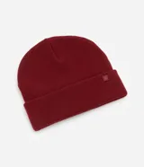 Gorro de punto tejido en color verde oliva, con diseño de borde plegado y una pequeña etiqueta rectangular aplicada en el frente.