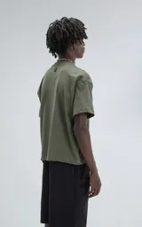 Remera de manga corta y cuello redondo, color verde militar, con calce boxy fit, caracterizada por ser ligeramente más corta y tener mangas amplias.