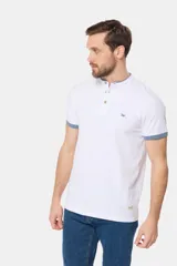 Remera blanca de manga corta con cuello mao y cierre frontal parcial con botones. Presenta detalles en color gris azulado en el cuello y en los bordes de las mangas.