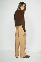 Pantalón de tiro bajo con diseño cruzado tipo pareo en el frente y lazo ajustable. Presenta pernera recta y cierre lateral con cremallera oculta.