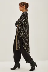 Kimono largo de jacquard con diseño de cebra y destellos de lurex. Presenta bordes con detalle de guarda tejida, mangas tres cuartos y forro interior.