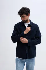 Sobrecamisa azul marino confeccionada en mezcla de lino y algodón, con cuello clásico, cierre frontal de botones, bolsillos aplicados en el pecho y bolsillos inferiores.