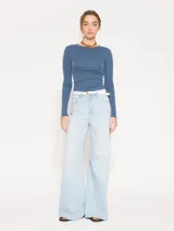 Remera de punto con textura suave, manga larga y escote redondo. Presenta un diseño ajustado al cuerpo con espalda abierta y largo a la primera cadera.