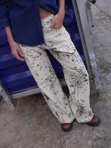 Jean de tiro medio y silueta recta levemente acampanada, con estampado tipo cowhide print. Cuenta con cierre frontal, botón y bolsillos funcionales.