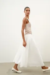 Top de punto canalé en color beige, con escote en pico adornado con una delicada aplicación de encaje blanco y tirantes anchos.