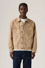 Campera estilo trucker de color marrón claro, confeccionada en gabardina resistente. Cuenta con cuello clásico, cierre frontal de botones metálicos, bolsillos frontales con solapa y bolsillos laterales ribeteados.