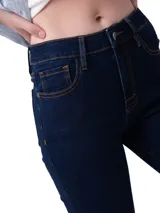 Jeans de corte ajustado y tiro medio en color azul oscuro. Presenta diseño clásico de cinco bolsillos, cierre frontal con cremallera y botón, y detalles de marca en los remaches y la pretina.
