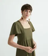 Vestido midi verde militar de algodón, con escote cuadrado, mangas cortas amplias y falda con volantes escalonados.