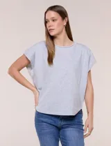 Remera de silueta amplia y relajada de color gris melange, confeccionada en algodón con poliéster. Presenta escote a la base con terminación rústica de borde enrollado, mangas cortas de hombro caído sin dobladillo y ruedo curvo con la parte posterior más larga.