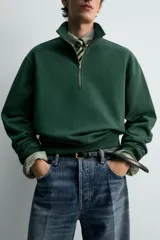 Sudadera de algodón azul con cuello alto y cierre frontal de cremallera de un cuarto. Presenta un corte regular y puños y bajo en rib.