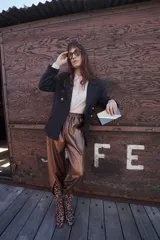 Blazer negro de corte clásico con doble botonadura dorada.