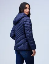 Campera de abrigo verde esmeralda, marca Michael Kors. Diseño acolchado con cierre metálico central, capucha no desmontable con cordón de ajuste y bolsillos verticales delanteros. Incluye bolsa autoportante.