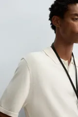 Polo de punto de corte regular fit, confeccionado en una mezcla de algodón y lyocell. Presenta cuello de solapa con cierre frontal de botones, manga corta y acabados en rib en puños y bajo.