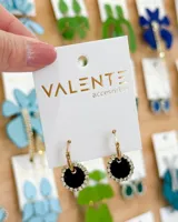 Aros colgantes dorados con dije circular negro con borde de strass. El aro es de acero.