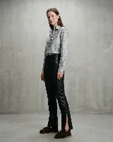 Pantalón de cuero vacuno color marrón, de corte recto y tiro medio. Presenta una cintura con detalle de presillas fruncidas en contraste negro y forrería interna de satén.