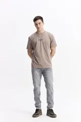 Pantalón de jean con corte slim, tiro medio y cierre frontal con botón y cremallera. Presenta un acabado lavado en tono gris claro, con costuras reforzadas y bolsillos laterales y traseros.