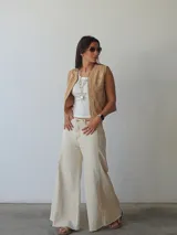 Pantalón de jean color natural, de corte ancho con costuras a la vista y terminación desflecada.