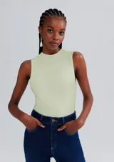 Musculosa ajustada de tejido acanalado color verde claro, con cuello mock (cuello tortuga bajo) y sin mangas.