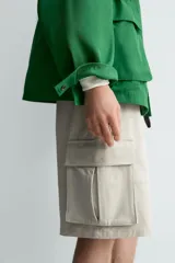 Bermuda cargo de algodón color beige claro, con corte relajado, bolsillos laterales de parche con solapa y bolsillos traseros de vivo.