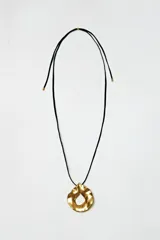 Collar con cordón negro y dije dorado con forma orgánica.