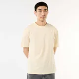 Camiseta de manga corta en color beige, con cuello redondo y diseño de ajuste cómodo y holgado.
