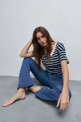 Jean flare de tiro medio, color celeste, con calce al cuerpo hasta la rodilla y pierna levemente acampanada.