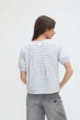 Camisa a cuadros de manga corta abullonada y cuello redondo, con cierre frontal de botones.